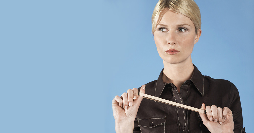 Young businesswoman stretching rubber band on blue background